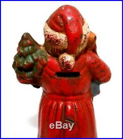 EARLY 20TH C ANTIQUE CAST IRON SANTA CLAUS HOLDING GIFTS COIN BANK, WithORIG PAINT